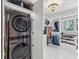 Organized closet with washer and dryer as well as custom shelving, drawers, and a chandelier at 8693 15Th N St, St Petersburg, FL 33702