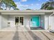 Charming front porch with stylish teal double doors and seating, enhancing curb appeal at 8693 15Th N St, St Petersburg, FL 33702