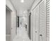 Bright hallway featuring a white tile floor and access to the bathroom and pantry at 8693 15Th N St, St Petersburg, FL 33702