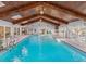 Indoor pool with wood ceilings, chandeliers, multiple seating areas, and sliding glass doors at 8693 15Th N St, St Petersburg, FL 33702