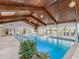 Indoor pool with wood ceilings, chandeliers, multiple seating areas, and sliding glass doors at 8693 15Th N St, St Petersburg, FL 33702