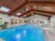 Indoor pool features wood ceilings, skylights, chandeliers, multiple seating areas, and sliding glass doors at 8693 15Th N St, St Petersburg, FL 33702