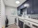 Laundry room with navy cabinets, tile backsplash, updated appliances, and shaker cabinets at 8693 15Th N St, St Petersburg, FL 33702