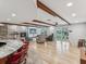 Open-concept living room featuring stone fireplace and beamed ceiling at 8693 15Th N St, St Petersburg, FL 33702