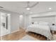 Main bedroom featuring hardwood floors, a ceiling fan, an arched doorway, and modern décor at 8693 15Th N St, St Petersburg, FL 33702