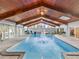 Indoor pool featuring a fountain, wood ceiling, and natural light streaming through windows for year-round enjoyment at 8693 15Th N St, St Petersburg, FL 33702