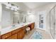 Bathroom with double vanity, large mirror, glass-enclosed shower, and neutral color palette at 10209 Spanish Breeze Ct, Riverview, FL 33578