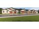 Street view of new construction homes with brown garage doors, neutral paint, and well manicured lawns at 10596 Gable Dig Loop, San Antonio, FL 33576