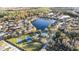 Aerial view of a community's amenities including a pool, tennis courts, and large lake at 10623 Pearl Berry Loop, Land O Lakes, FL 34638