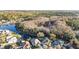 Aerial view showcasing neighborhood homes nestled near a scenic lake and lush greenery at 10623 Pearl Berry Loop, Land O Lakes, FL 34638