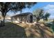 Exterior view of the home featuring a screened patio, fenced yard, and view of the lake at 10623 Pearl Berry Loop, Land O Lakes, FL 34638