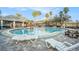 Community pool surrounded by lounge chairs and a clubhouse, perfect for relaxation and recreation at 10623 Pearl Berry Loop, Land O Lakes, FL 34638
