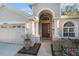 Close-up showcasing a front door flanked by columns and decorative plants, exuding elegance at 10623 Pearl Berry Loop, Land O Lakes, FL 34638