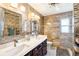 Well-lit bathroom showcasing a double sink vanity, decorative mirrors, and elegant tile work at 10801 Cedar Breaks Dr, Port Richey, FL 34668