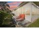 Back exterior of a sunroom featuring lounge chairs, sliding glass windows, and a peaceful backyard at 10801 Cedar Breaks Dr, Port Richey, FL 34668