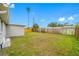 Large backyard with a privacy fence and a single palm tree at 10836 Inglewood Ave, Port Richey, FL 34668