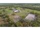 Elevated aerial view displaying barns, riding arena, and pastures, on a expansive horse farm estate at 1126 Oxbow Rd, Wimauma, FL 33598