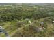 Beautiful aerial view of wooded acreage and charming home on large lot with mature trees at 1126 Oxbow Rd, Wimauma, FL 33598