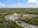 Expansive acreage with winding driveway leads to a charming home nestled amid lush greenery, offering privacy and a serene retreat at 1126 Oxbow Rd, Wimauma, FL 33598