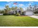 Attractive single-story home with a manicured lawn and an American flag in a peaceful, residential setting at 1126 Oxbow Rd, Wimauma, FL 33598