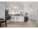Open concept kitchen with breakfast bar, white and blue cabinets, and stylish pendant lighting at 1126 Oxbow Rd, Wimauma, FL 33598