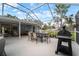 This screened patio features comfortable seating and an outdoor grill for relaxed entertaining at 1126 Oxbow Rd, Wimauma, FL 33598