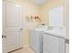 Bright laundry room with white washer and dryer units, complementary shelving, and natural light at 11395 Lavender Loop, Spring Hill, FL 34609