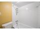 Bright bathroom featuring a white tiled shower-tub combination, modern fixtures, and a yellow wall at 11485 Oakhurst Rd # 111, Largo, FL 33774
