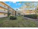 Exterior view of a condo building surrounding a courtyard with lush green landscaping and mature trees at 11485 Oakhurst Rd # 111, Largo, FL 33774