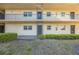 Exterior view of building featuring a courtyard with manicured shrubs along the base of the building at 11485 Oakhurst Rd # 111, Largo, FL 33774