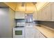 Kitchen with pass-through and white appliances and countertop at 11485 Oakhurst Rd # 111, Largo, FL 33774