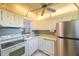 Kitchen features white appliances, cabinetry, and a decorative pass-through to the living room at 11485 Oakhurst Rd # 111, Largo, FL 33774