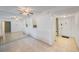 Open living room featuring tile flooring, an accent mirror wall and a view into the kitchen at 11485 Oakhurst Rd # 111, Largo, FL 33774