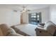 Bright living room features sliding glass doors to the lanai and a ceiling fan at 11485 Oakhurst Rd # 111, Largo, FL 33774