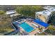 Aerial view of a swimming pool with lounge chairs and umbrellas surrounding it for relaxing at 11485 Oakhurst Rd # 111, Largo, FL 33774