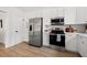 This kitchen features stainless steel appliances, white cabinets and wood-look flooring at 1201 10Th S Ave, St Petersburg, FL 33705