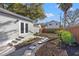 Backyard featuring professional landscaping with a stone pathway, grass and shrubs, and rear garage access at 1205 13Th N St, St Petersburg, FL 33705