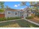 Cozy home with a blue front door, a well-maintained lawn, and a charming covered porch at 1205 13Th N St, St Petersburg, FL 33705
