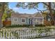 Charming one-story home featuring a blue front door, inviting porch, and lovely white picket fence at 1205 13Th N St, St Petersburg, FL 33705