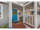 Welcoming front porch with a bright blue door, brick steps, and cozy seating area at 1205 13Th N St, St Petersburg, FL 33705