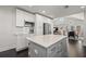 Open-concept kitchen with central island, stainless appliances, white cabinets, and view into dining and living areas at 1205 13Th N St, St Petersburg, FL 33705