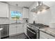 White kitchen with stainless steel appliances, subway tile backsplash, and a bright window at 1205 13Th N St, St Petersburg, FL 33705