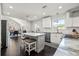 Open-concept kitchen with white cabinets, stainless steel appliances, and island with barstool seating overlooking dining room at 1205 13Th N St, St Petersburg, FL 33705