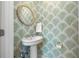 Charming powder room with green palm wallpaper, pedestal sink, and a round wicker mirror at 1205 13Th N St, St Petersburg, FL 33705