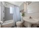 Bathroom with blue shower curtain, light gray tile walls and vintage sink and fixtures at 1213 1St St, Indian Rocks Beach, FL 33785