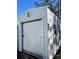 Exterior view of an outbuilding with a roll-up door and windows at 12403 Brick Cobblestone Dr, Riverview, FL 33579