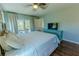 Bedroom featuring hardwood floors, sliding glass door, and blue accent wall at 1319 Saddle Ct, Palm Harbor, FL 34683