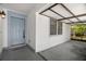 Welcoming entryway with a covered carport, gray front door, and textured white walls at 1368 Noell Blvd, Palm Harbor, FL 34683