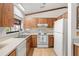 Classic kitchen featuring wood cabinets, white countertops, and white appliances at 1368 Noell Blvd, Palm Harbor, FL 34683