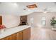 Open concept living room and kitchen featuring a brick fireplace and vaulted ceilings at 1368 Noell Blvd, Palm Harbor, FL 34683